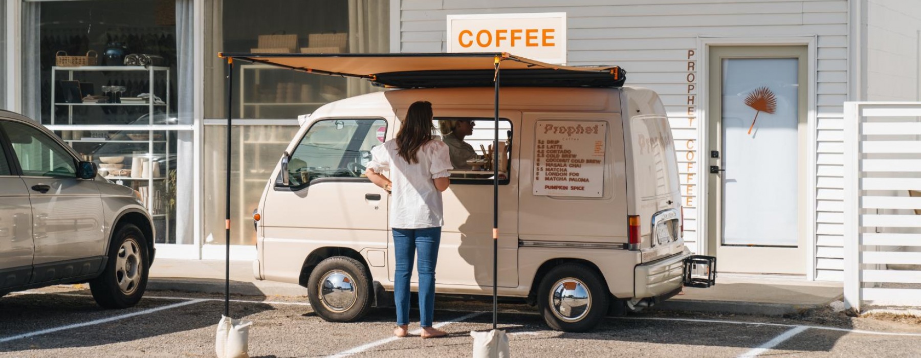 a person standing next to a coffee van